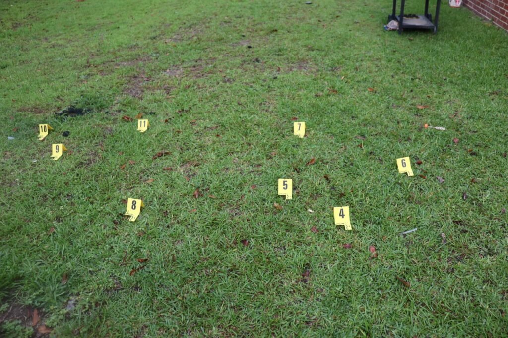 Yellow evidence markers in the side yard marking spent .40 caliber casings